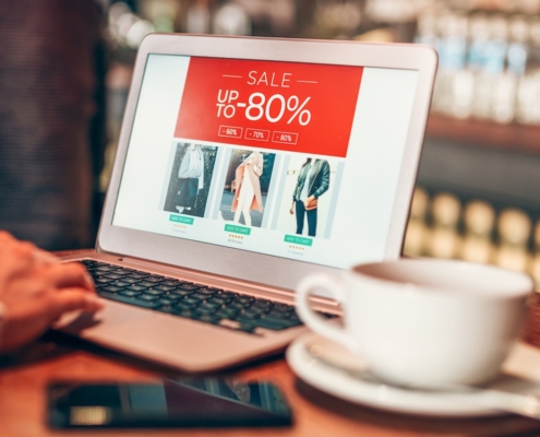 Laptop open on a retail site with a sale banner at the top
