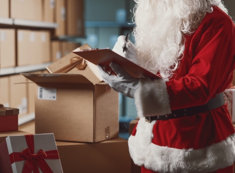 Santa in a warehouse making a list