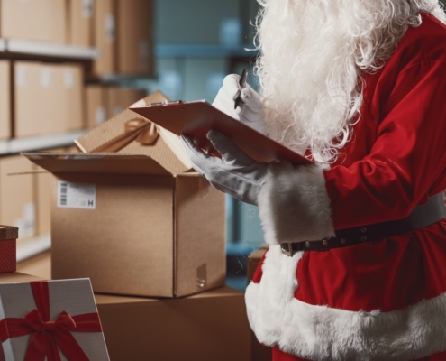 Santa in a warehouse making a list