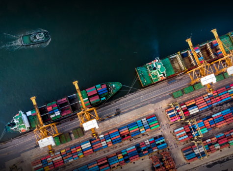 Cargo ship with crane bridge in shipyard.