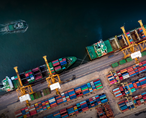 Cargo ship with crane bridge in shipyard.